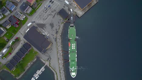 aerial birdseye view of cars being loaded onto the ferry at gryllefjord after waiting hours due to the high demand