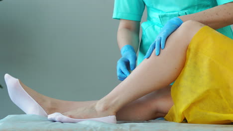 close-up in the beauty salon master in gloves doing the procedure to remove the hair on the legs with a sugar mixture