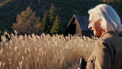 senior woman with binoculars in a field