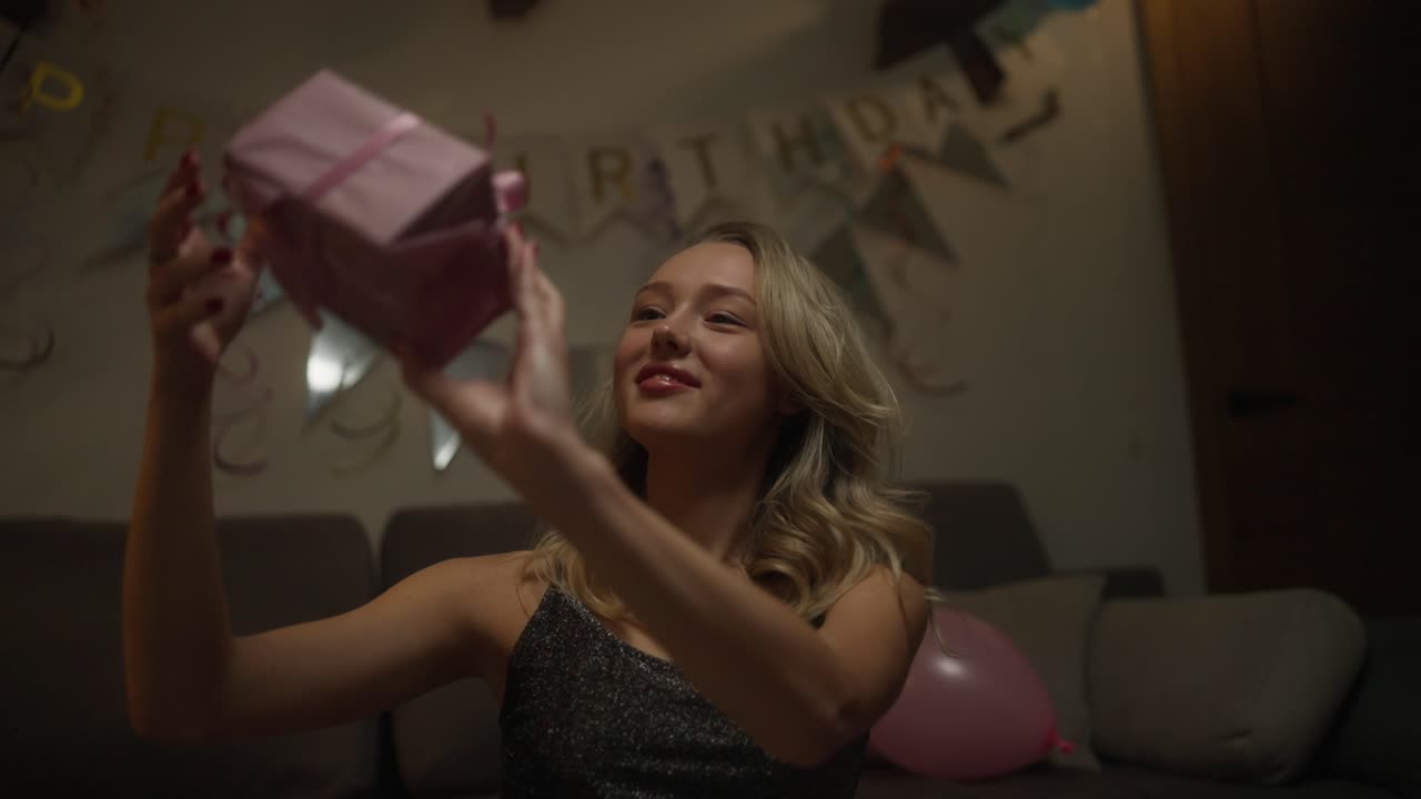 십대 소녀 가 생일 선물 을 열고 있다