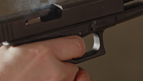 primer plano de la pistola glock 17 disparada y expulsando la carcasa