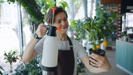 Woman spraying a citrus tree in a flower shop