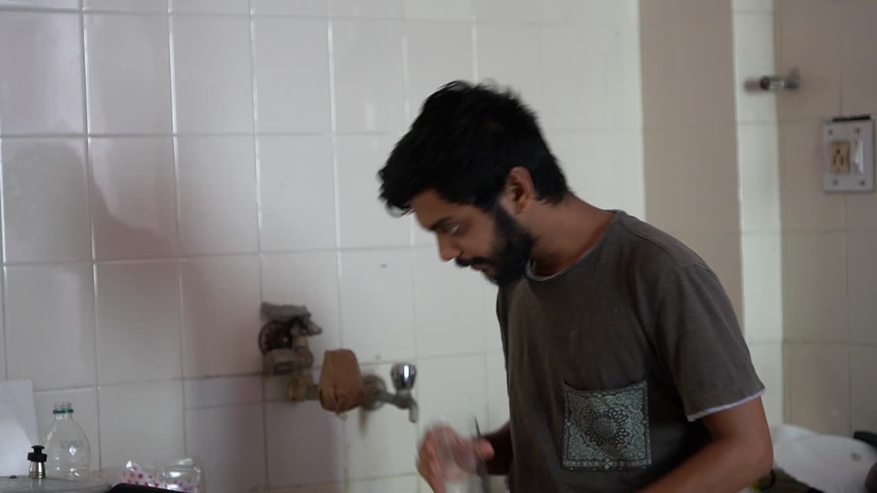hombre barba bebiendo agua en la cocina