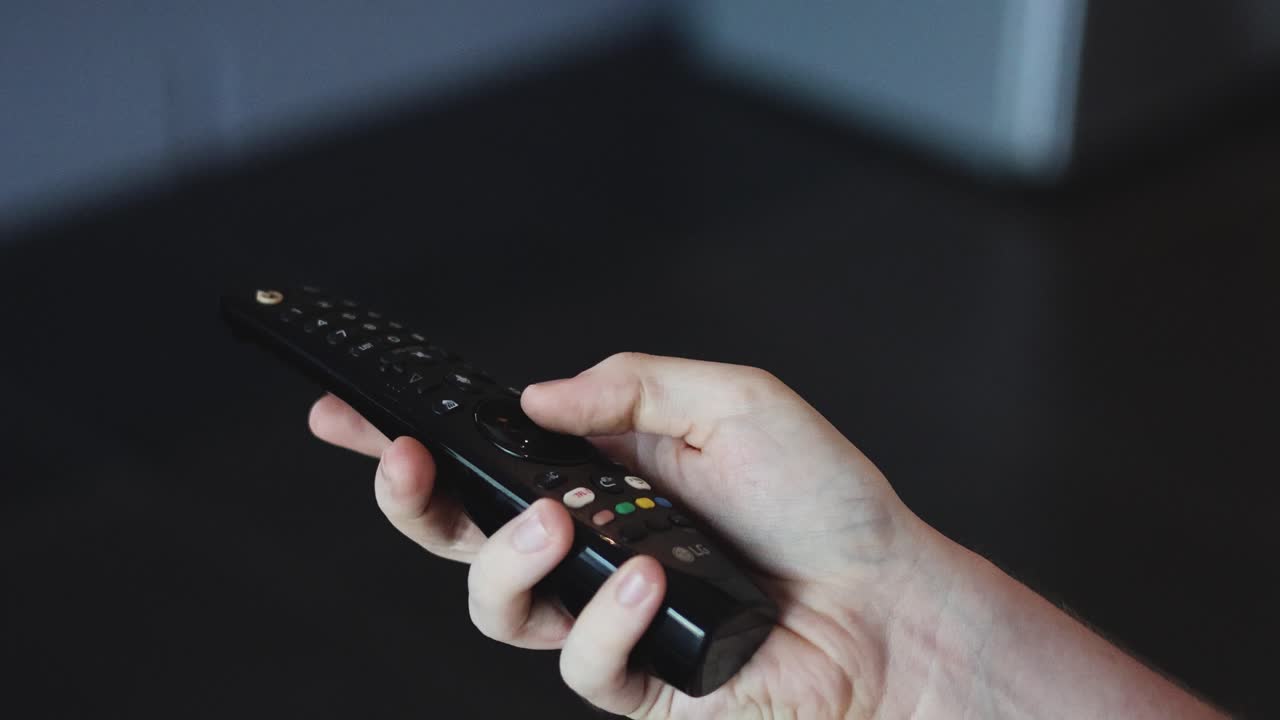 tv 리모컨 장치를 조작하는 손