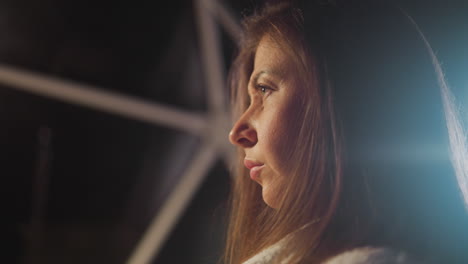 pensive woman with serious expression on face thinks about painful situations in dimly lit apartment room. lonely thinking and depression at twilight