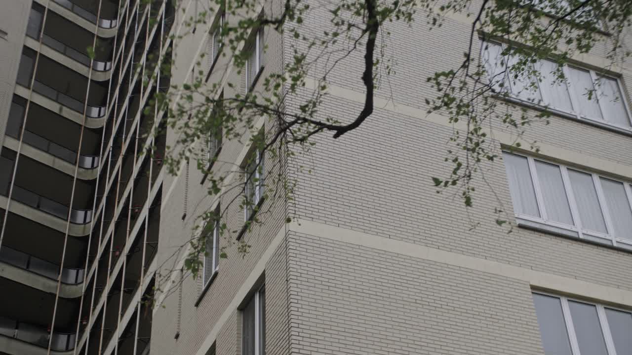 Smooth gimbal arc shot of an apartment building, highlighting urban residential life and social housing