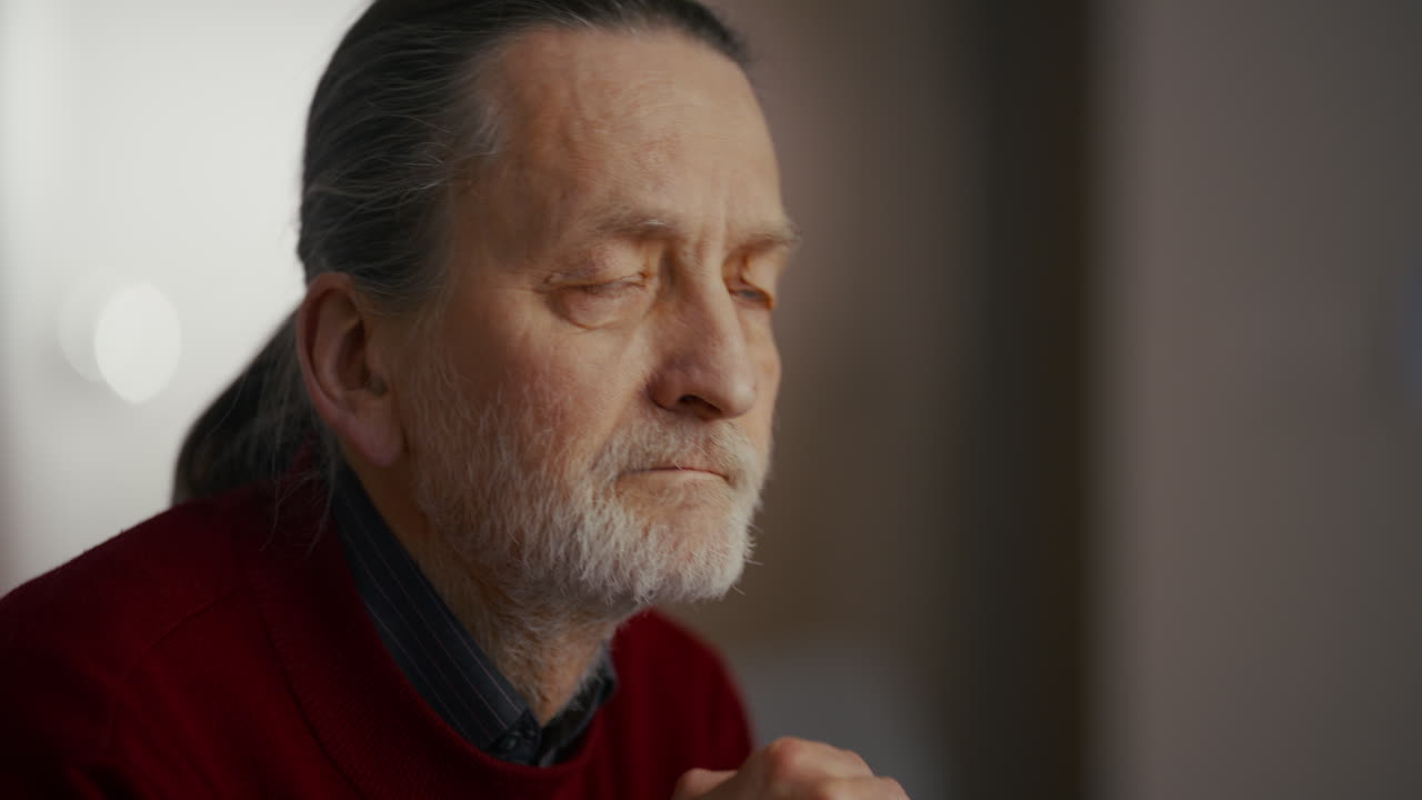 Elderly Man Looking Thoughtfully While Holding a Walking Stick