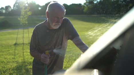 angry man with depression spraying water on a car standing in place as a concept for depression