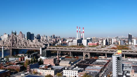 Vehicles-Driving-At-Queensboro-Bridge-With-Ravenswood-Generating-Station-Smoke-Stacks-In-The-Background-From-Hunter's-Point-In-New-York-City,-USA