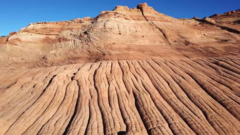 rocky cliffs and sandy ground on sunny day in desert terrain