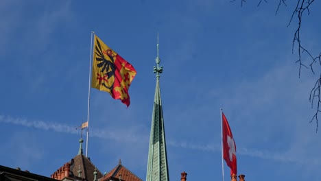 A-static-shot-of-the-Geneva-and-Switzerland-flags-flying-on-the-roof-of-St