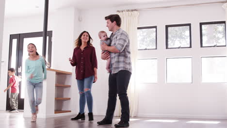 excited family with baby exploring new home on moving day