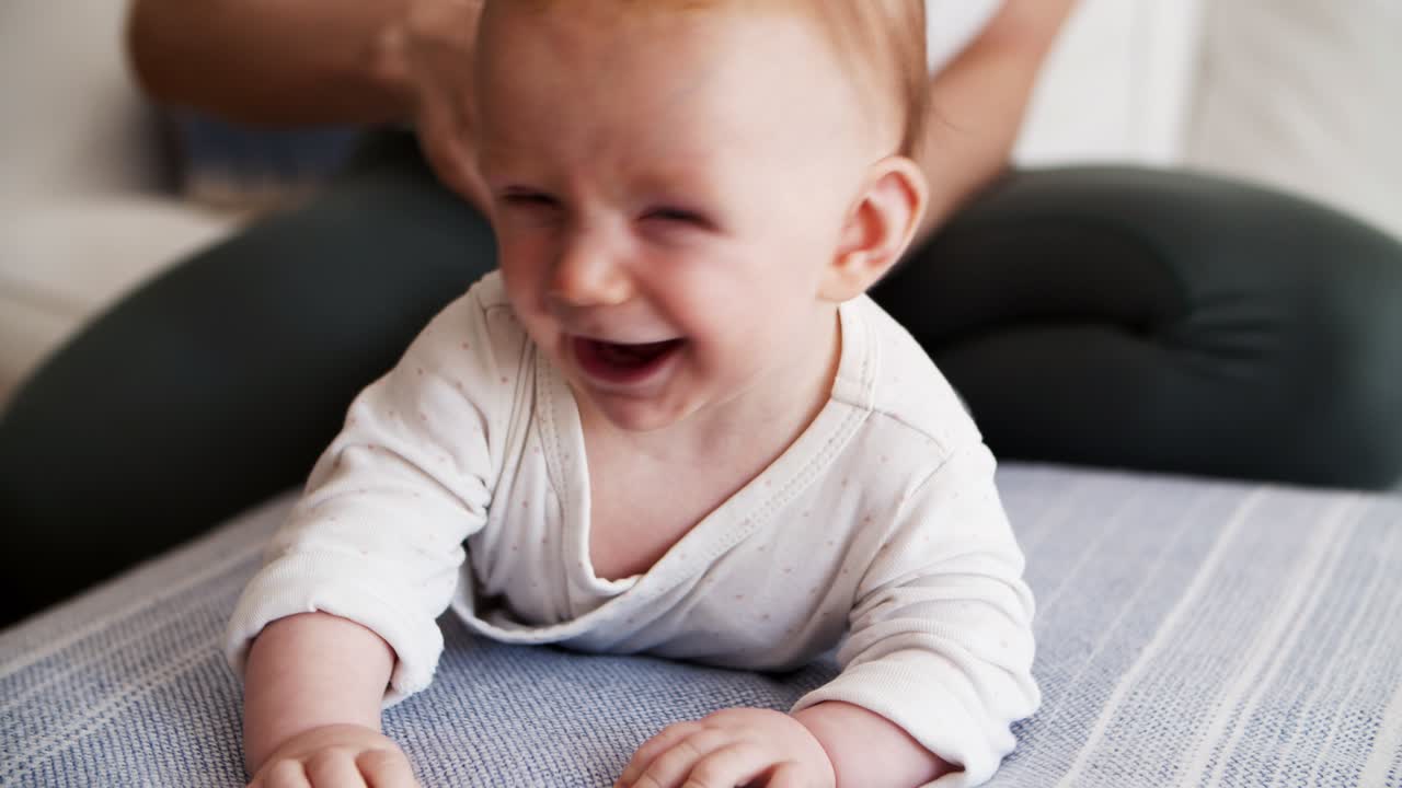 bebé de cabello rojo feliz acostado en el vientre
