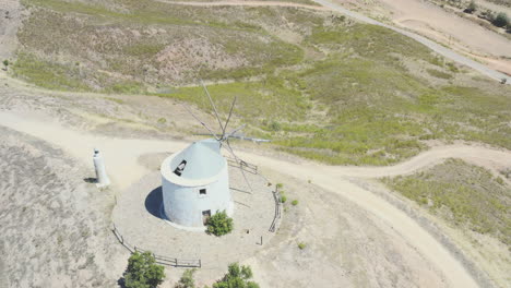 drone flight over an old traditional portuguese windmill on a mountain, overviewing the landscape around