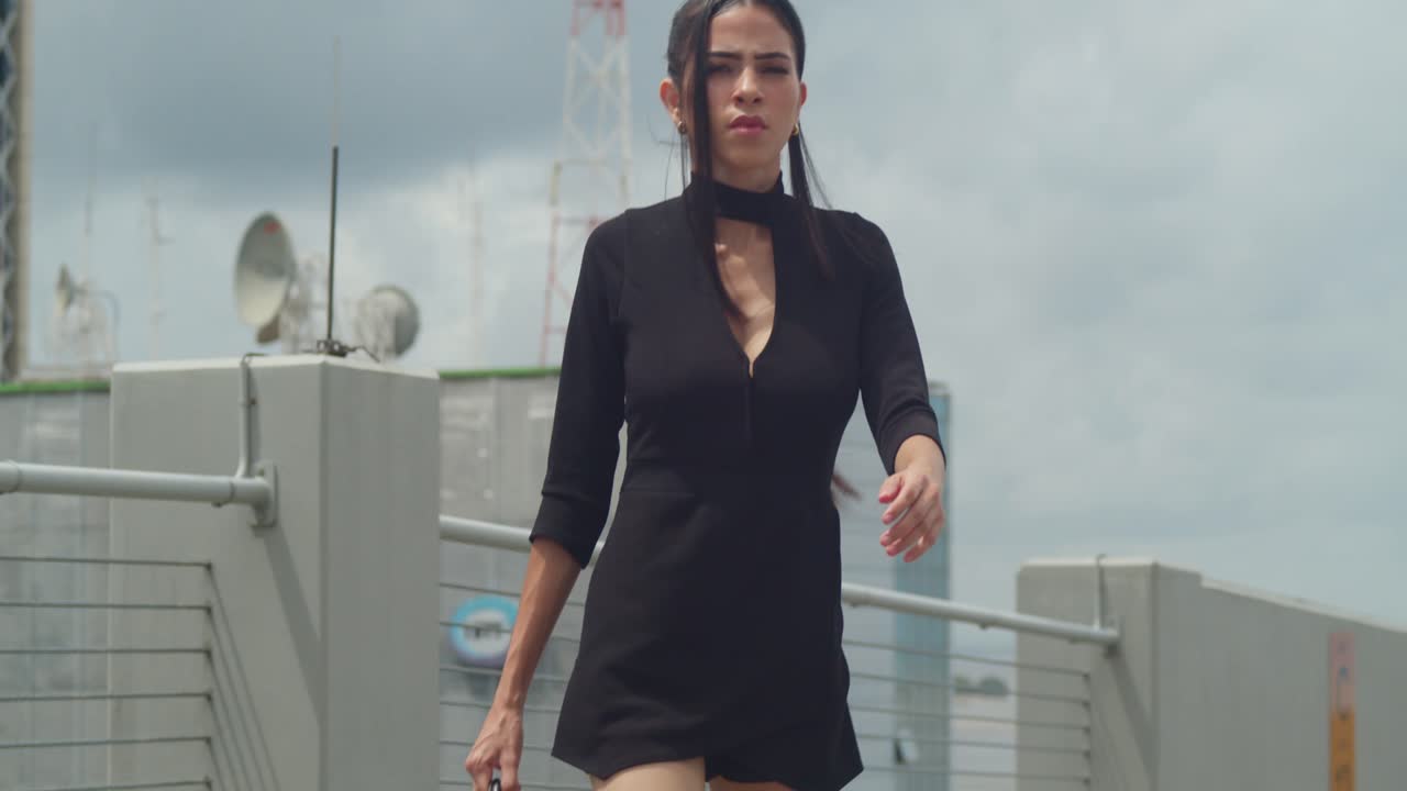 Woman in black walking on a city rooftop