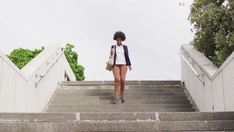 Mujer-De-Negocios-Afroamericana-Sosteniendo-Café-Para-Llevar-Y-Caminando