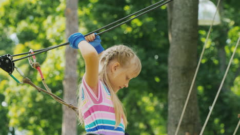 A-Brave-Girl-Moves-Along-The-Ropes-Between-The-Trees-Uses-A-Safety-Rope