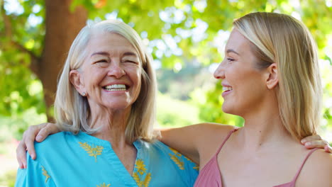 Porträt-Einer-Mehrgenerationenfamilie-Mit-älterer-Mutter-Und-Erwachsener-Tochter,-Die-Im-Garten-Lachen