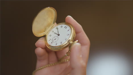 Die-Hand-Einer-Frau-Hebt-Eine-Taschenuhr-In-Den-Rahmen-Und-öffnet-Sie,-Bevor-Sie-Sie-Wieder-Schließt