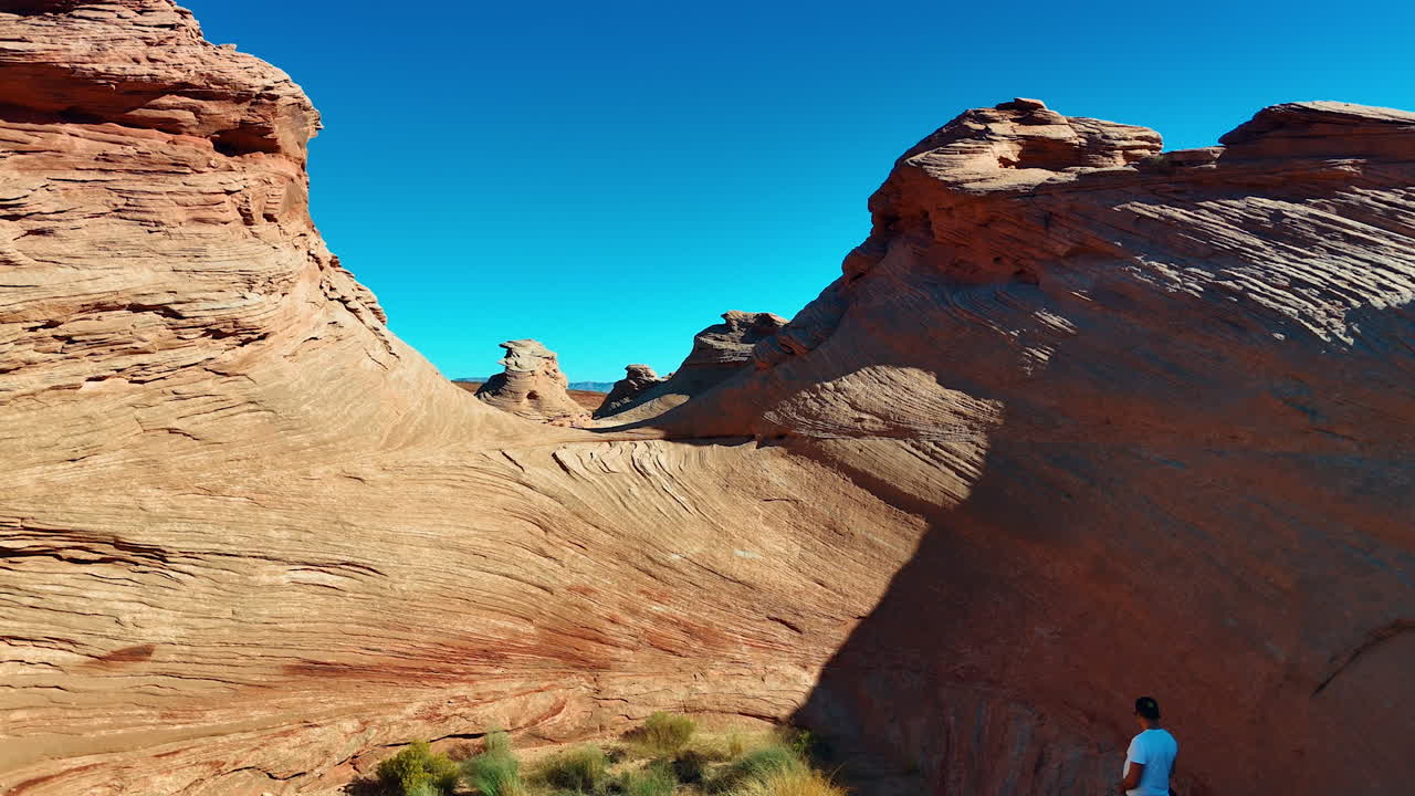 Uomo in piedi nell'alcova creata dalle scogliere di arenaria di forma spettacolare. Filmato aereo con drone sulle bizzarre formazioni rocciose in Arizona, vicino a Page, USA