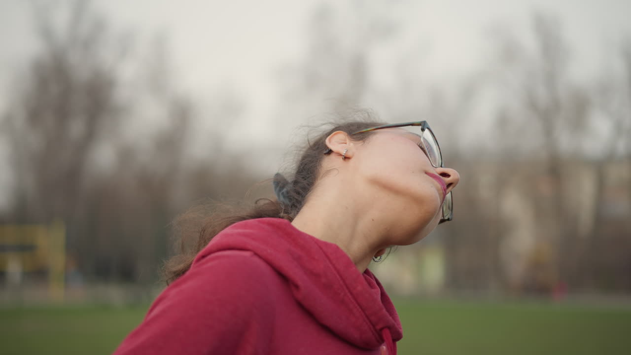 Long Hair Flip Outdoors Behind Building, Voluminous Curly Ponytail Captured From Back And Side With Head Tilt And Glasses, Cinematic Slow Motion Showing Texture, Scrunchie Detail And Architectural