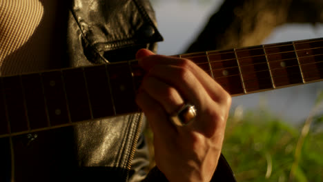 persona que toca la guitarra acústica