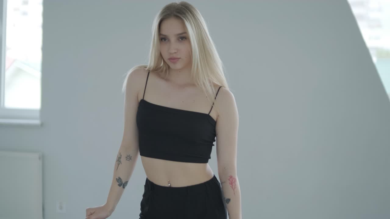 흑색 옷을 입은 소녀가 동시대를 선보이며, 여성 댄서가 하 방에서 흐르는 움직임, 몸과 손의 파동을 보여줍니다. 현대 발레 댄스 안무. 젊은 여성이 부드럽게 움직이고 있습니다.