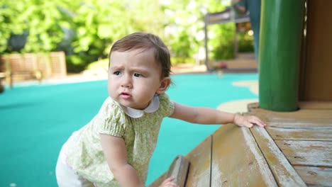 Linda-Niña-De-15-Meses-De-Etnia-Mixta-Trepando-En-Equipo-De-Madera-En-El-Patio-De-Recreo