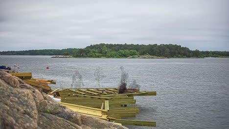 Statische-Aufnahme-über-Einem-Großen-Holzsteg,-Der-Tagsüber-Von-Arbeitern-Im-Zeitraffer-In-Das-Wasser-Eines-Sees-Gebaut-Wurde