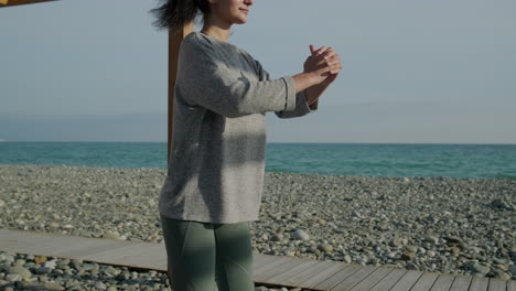 mujer estirándose en la playa