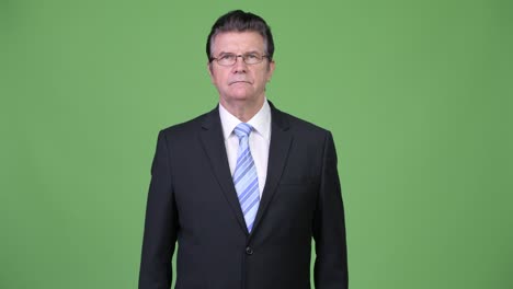 frustrated senior handsome businessman giving thumbs down