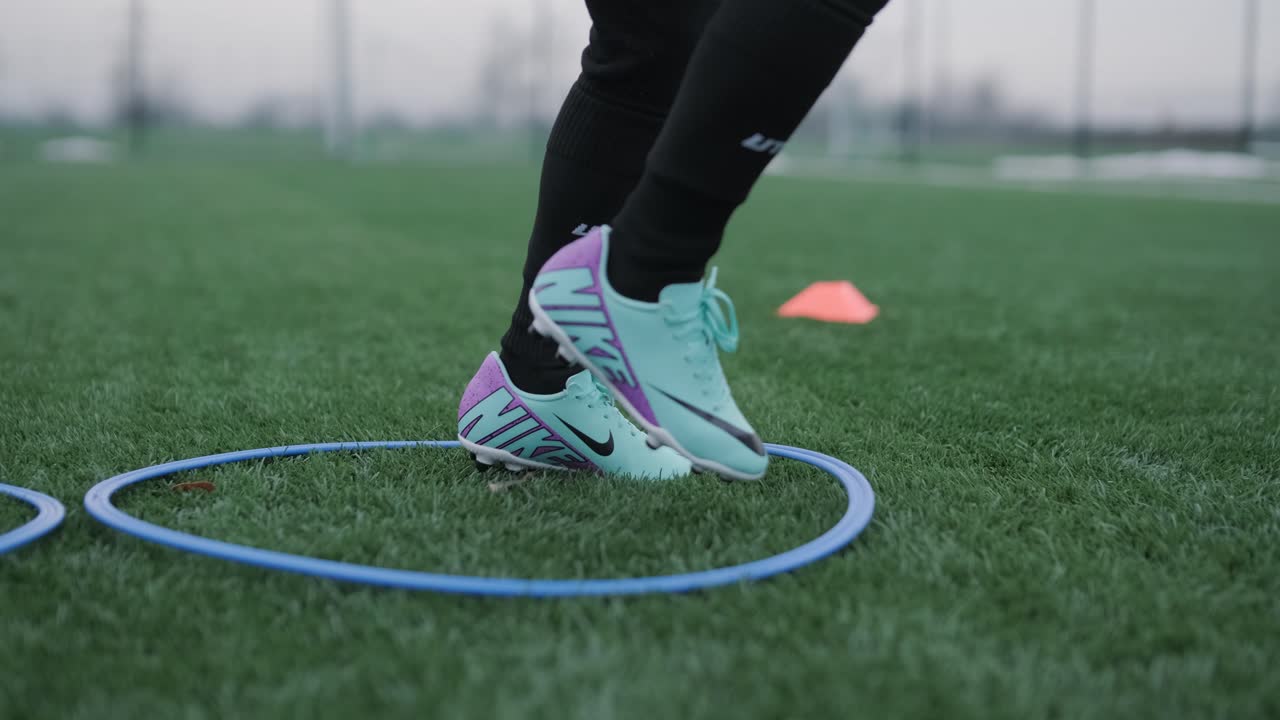 Una squadra di calcio per bambini si allena allo stadio sotto la guida di un allenatore. I bambini in divisa sportiva praticano esercizi con la palla, migliorano la tecnica e sviluppano il lavoro di squadra sul campo verde