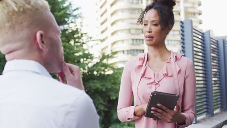 Diverse-business-people-discussing-with-tablet-in-creative-office