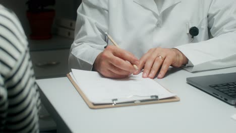 doctor filling out medical paperwork during a consultation