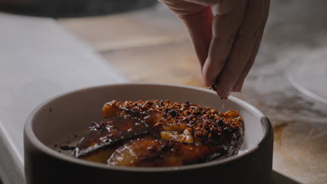 garnishing a plate of sauteed sweet potatoes