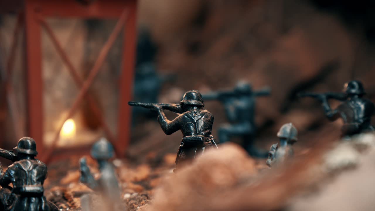 Diorama di guerra con soldatini di plastica in miniatura in combattimento. Una candela in una lanterna che fornisce luce calda alla scena di battaglia con effetti di fumo