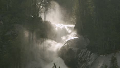 shannon falls pounds the rocks below it with large trees flanking the sides