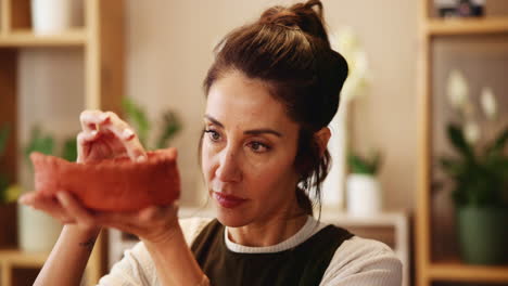 woman examining a clay bowl