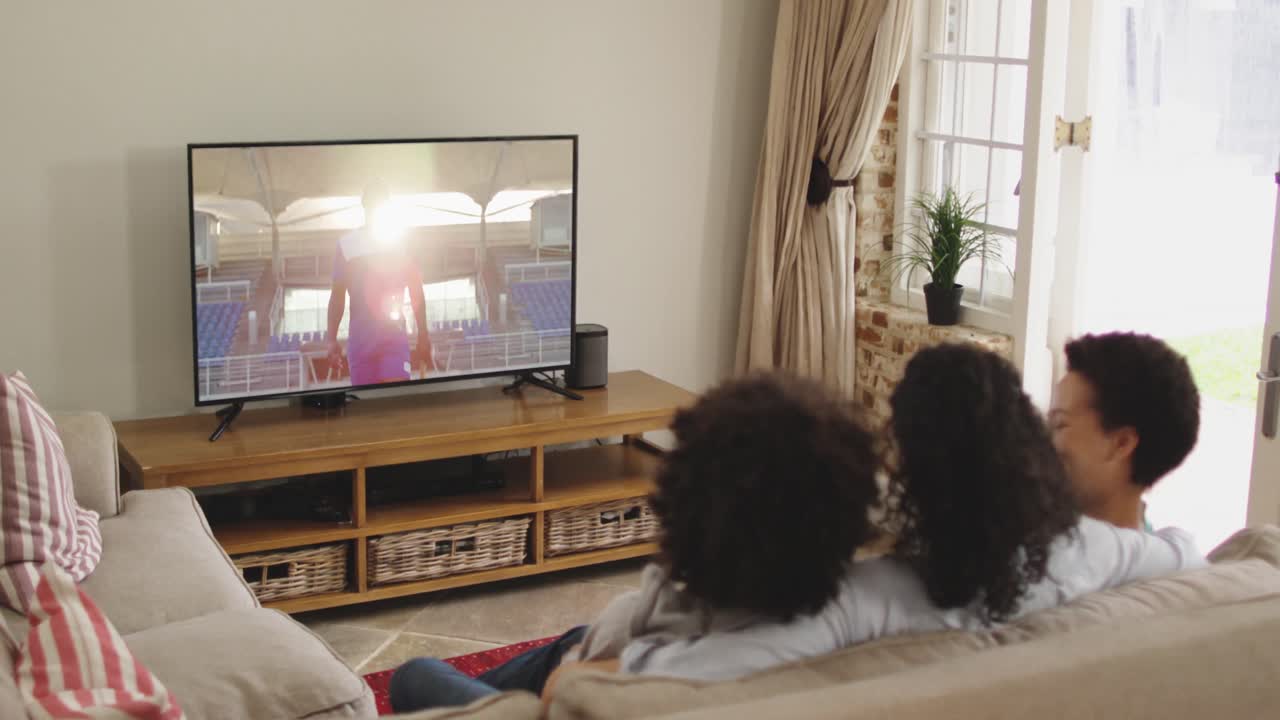 Famiglia felice seduta a casa insieme che guarda un evento sportivo in TV