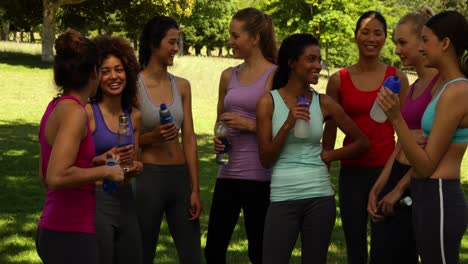 clase de fitness tomando un descanso y charlando en el parque