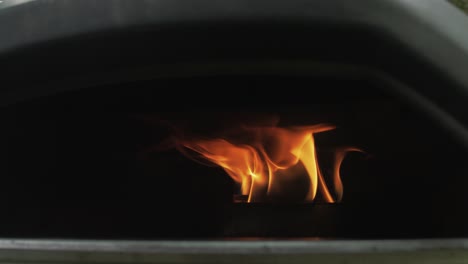 flames inside a portable pizza oven