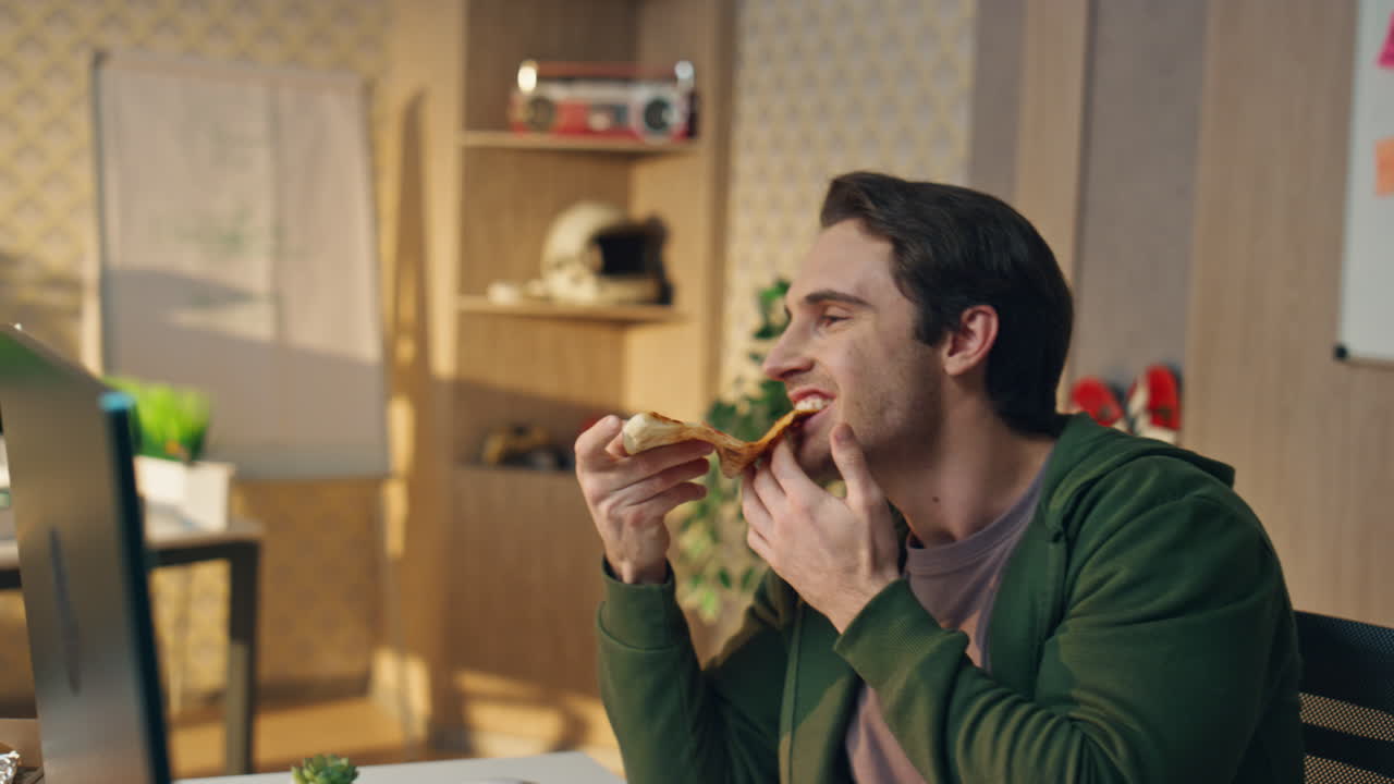 hombre con la mano tomando una rebanada de pizza en el lugar de trabajo en primer plano. diseñadores almorzando hablando