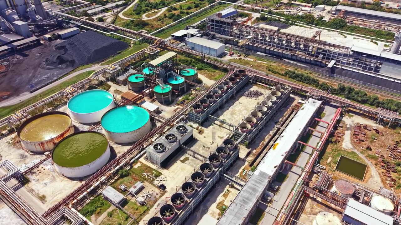 Industrial site with water treatment tanks and storage facilities near a manufacturing plant
