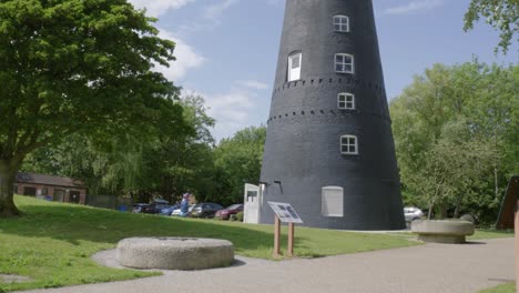 historic windmill with millstones and info signs in a green park setting, hessle