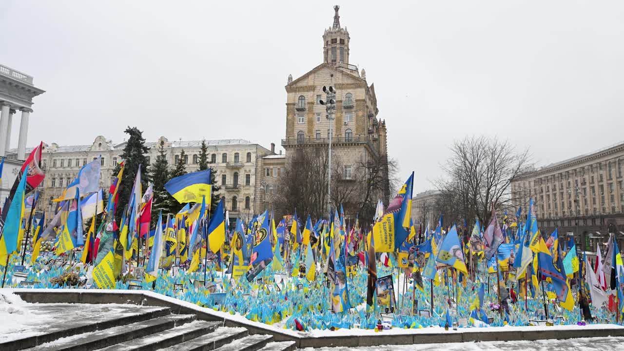 Ukrainian and international flags line a war memorial in Kyiv’s Independence Square, paying tribute to fallen soldiers—a moving display of remembrance and loss in the ongoing conflict.