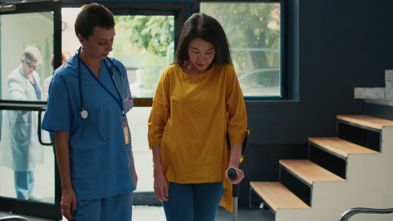 Nurse Assisting Patient with Crutches in Hospital Waiting Room