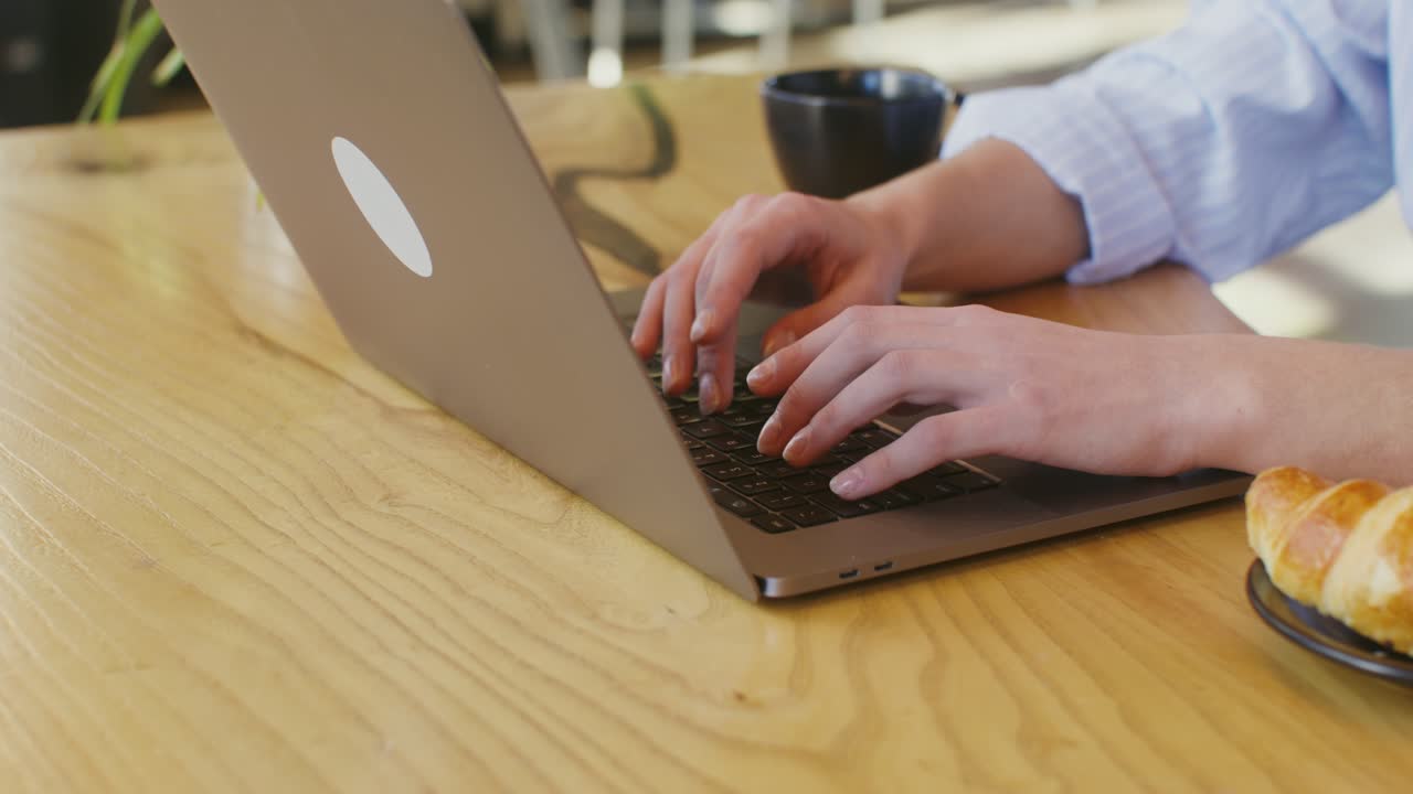 Woman Working on Laptop in a Cafe