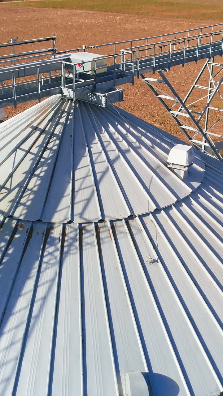 Aerial view. Metal grain elevator in agricultural zone. Grain warehouse Vertical video