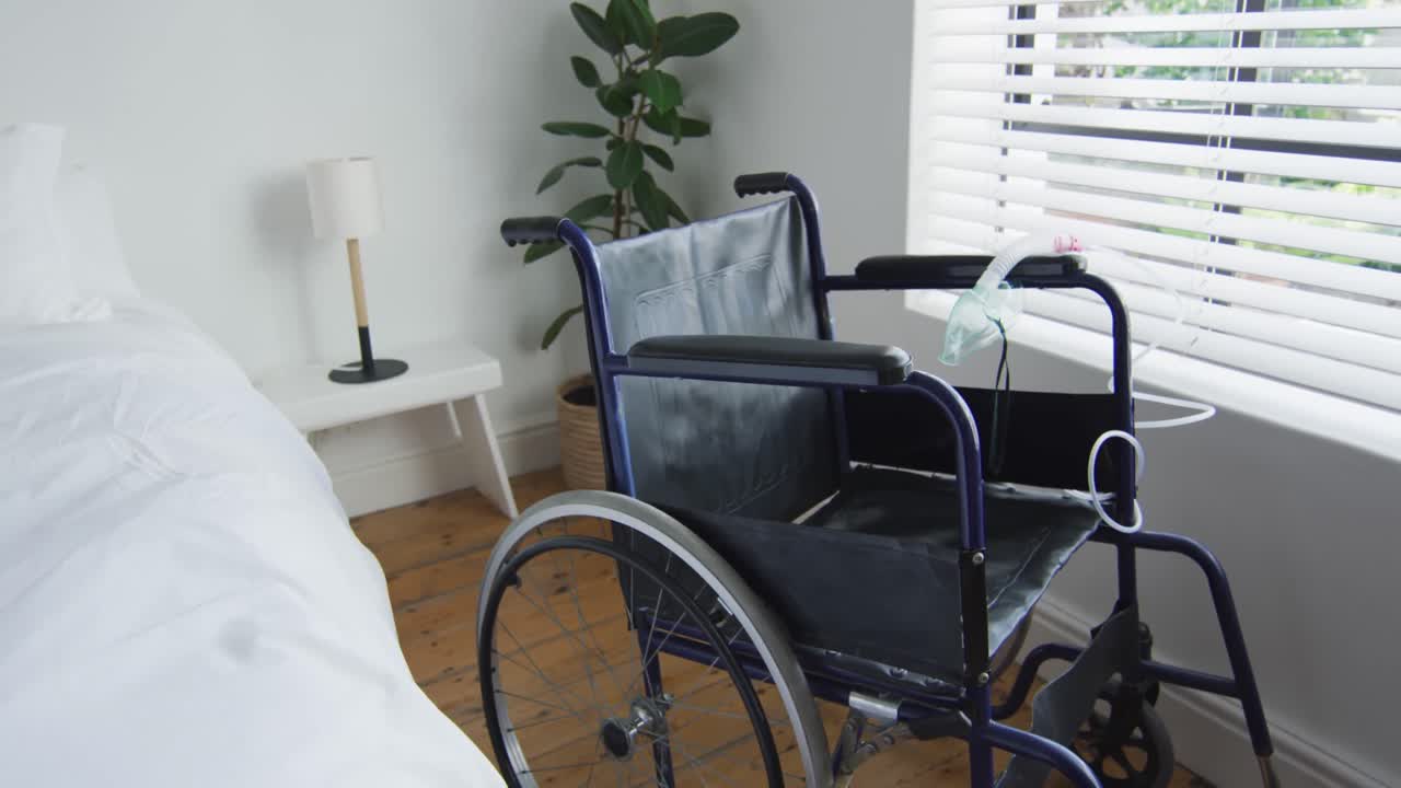 Sedia a rotelle vuota per disabili e maschera per l'ossigeno in camera da letto