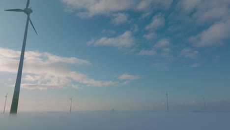 在風力發電廠中產生可再生能源的風力<unk>輪的空中拍攝, 雪覆蓋的鄉村風景, 霧<unk>, 陽光充<unk>的冬天晚上, 黃金時間, 寬<unk>無人機拍攝, 向前移動低